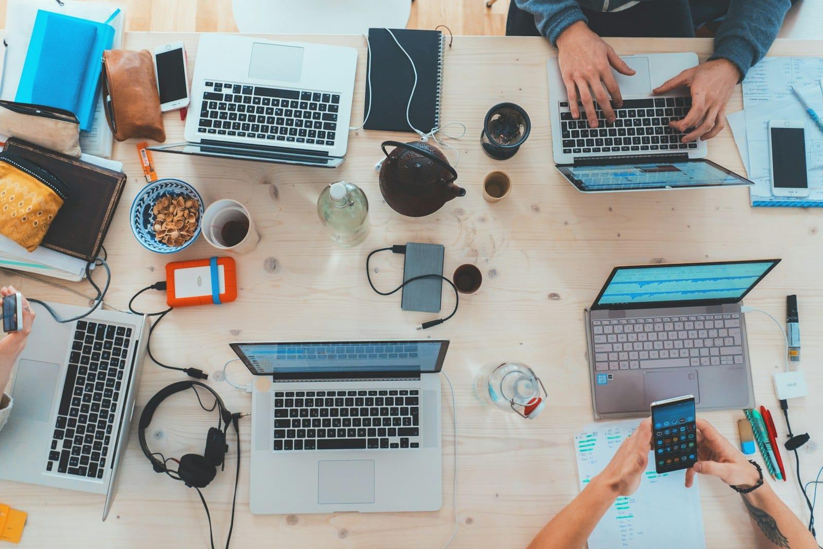 Table de travail couverte d'ordinateurs portables et d'appareils électroniques